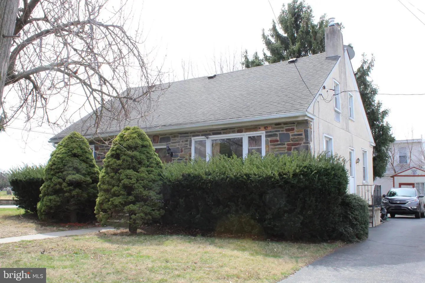 Stone suburban house with evergreen shrubs