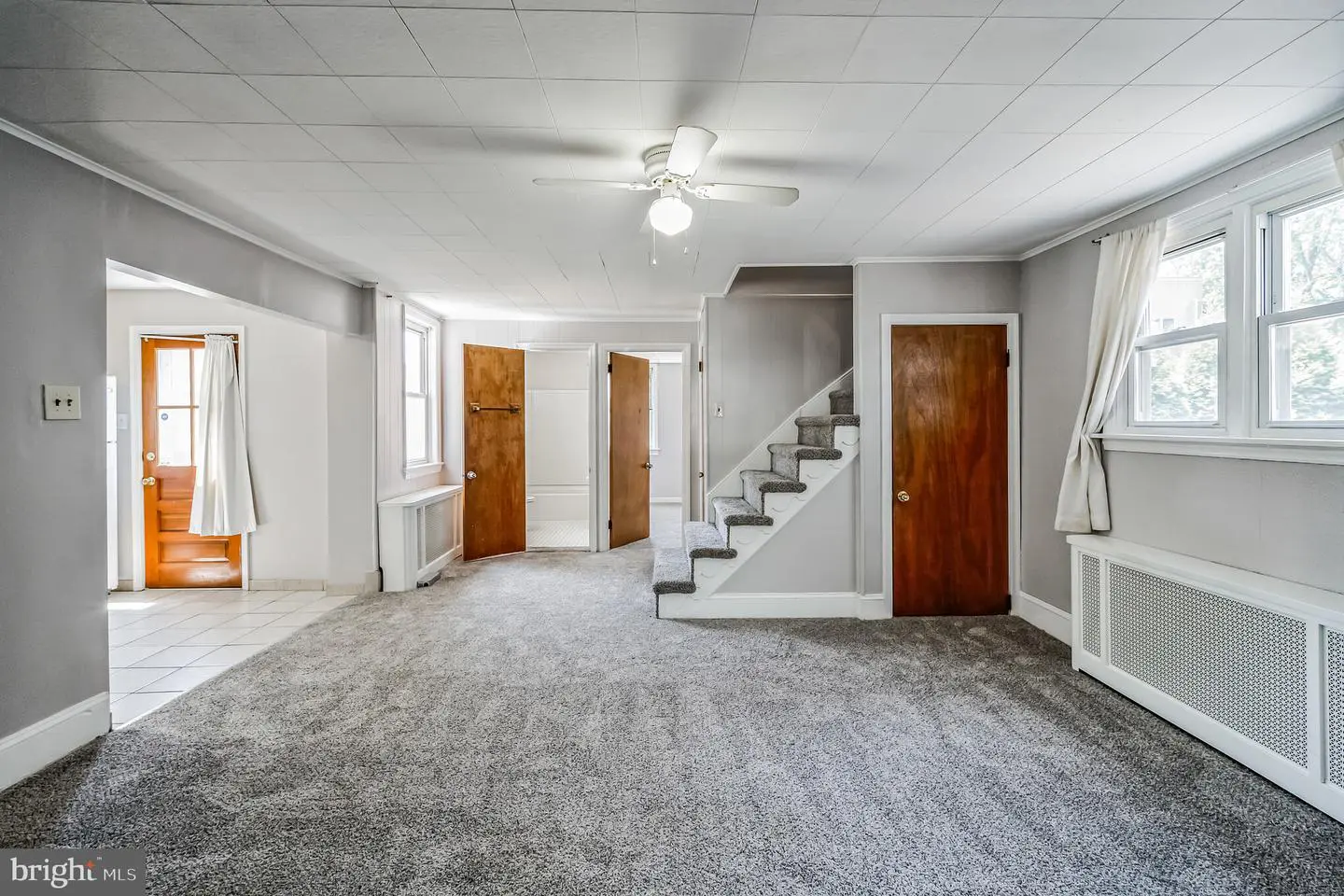 Empty living room with staircase and carpet