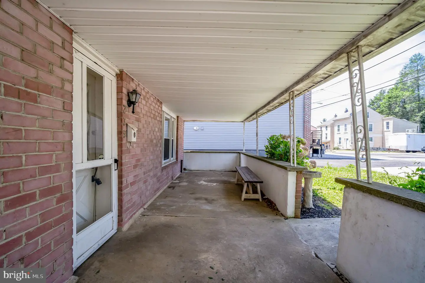 Covered brick front porch with bench