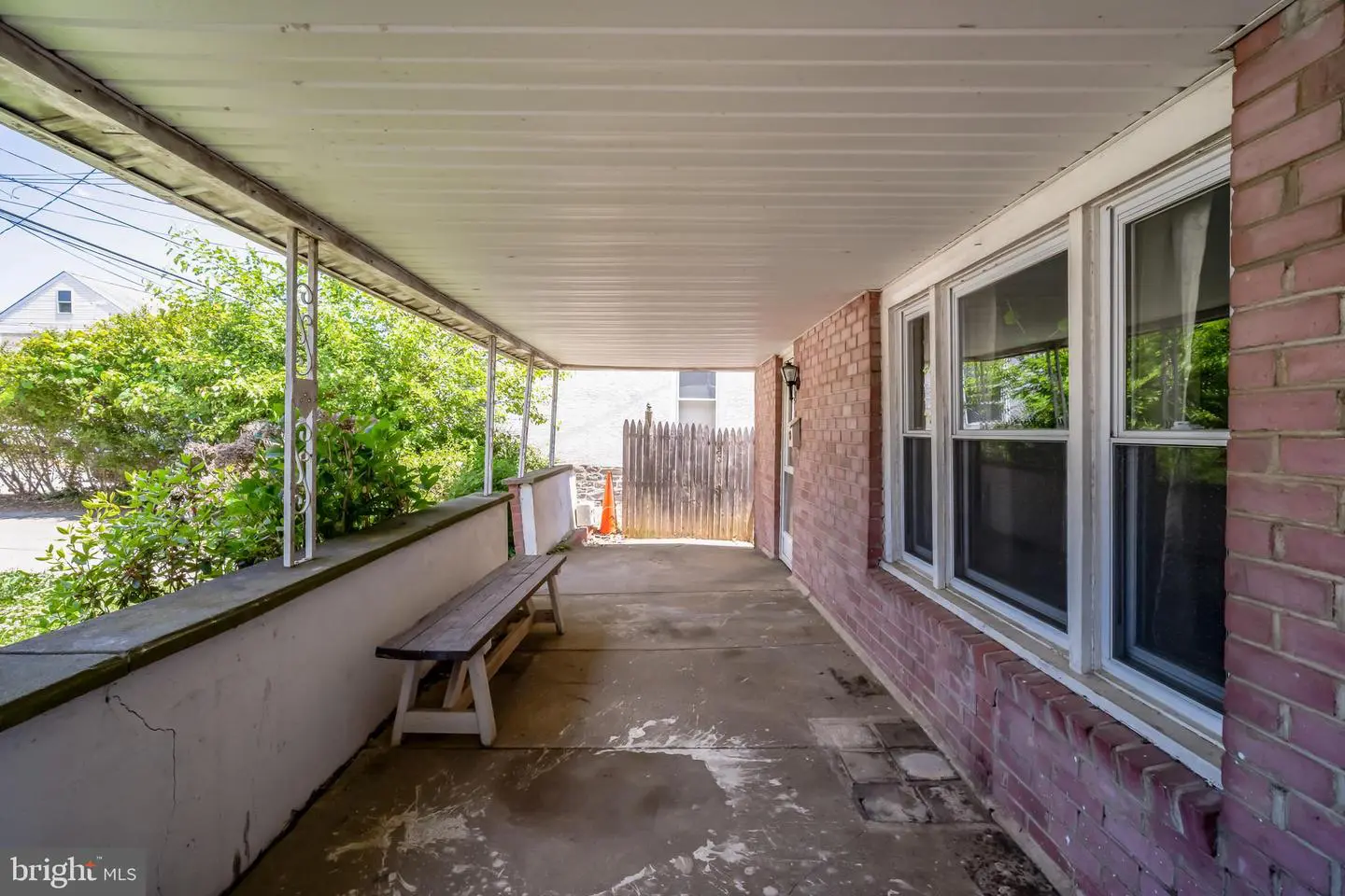 Covered front porch with bench and windows