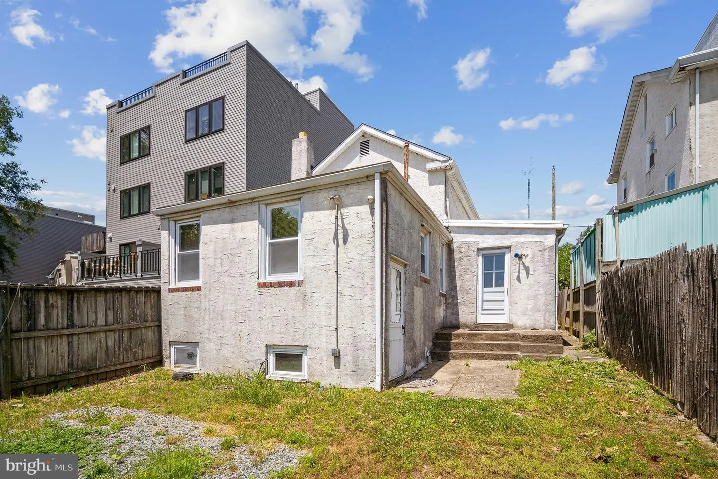 Small white house with fenced backyard