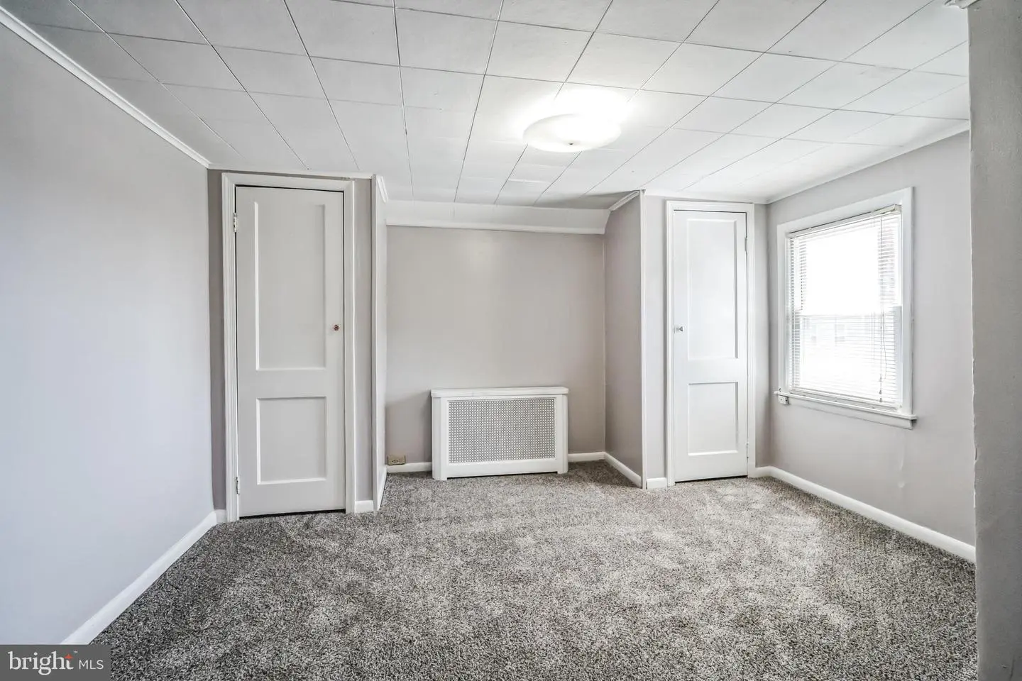 Empty carpeted bedroom with two closets