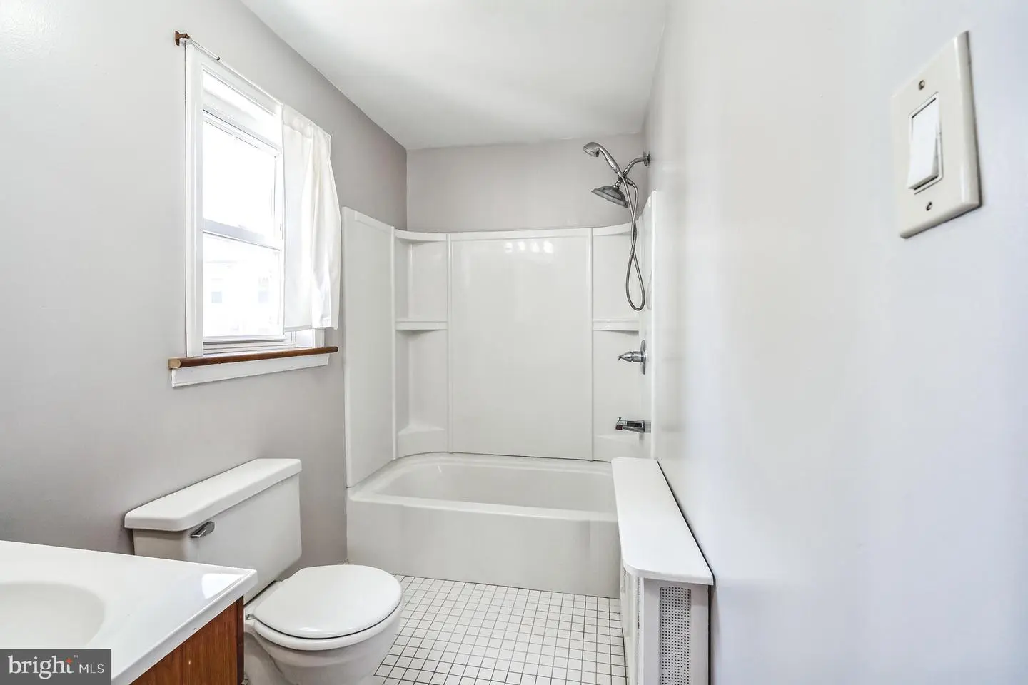 Bright bathroom with tub, shower, and toilet