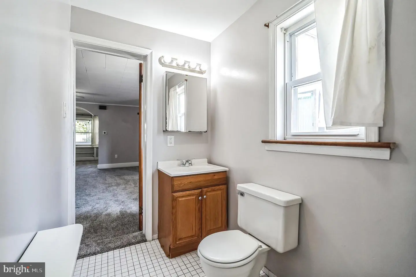 Small bathroom with toilet, vanity, and window