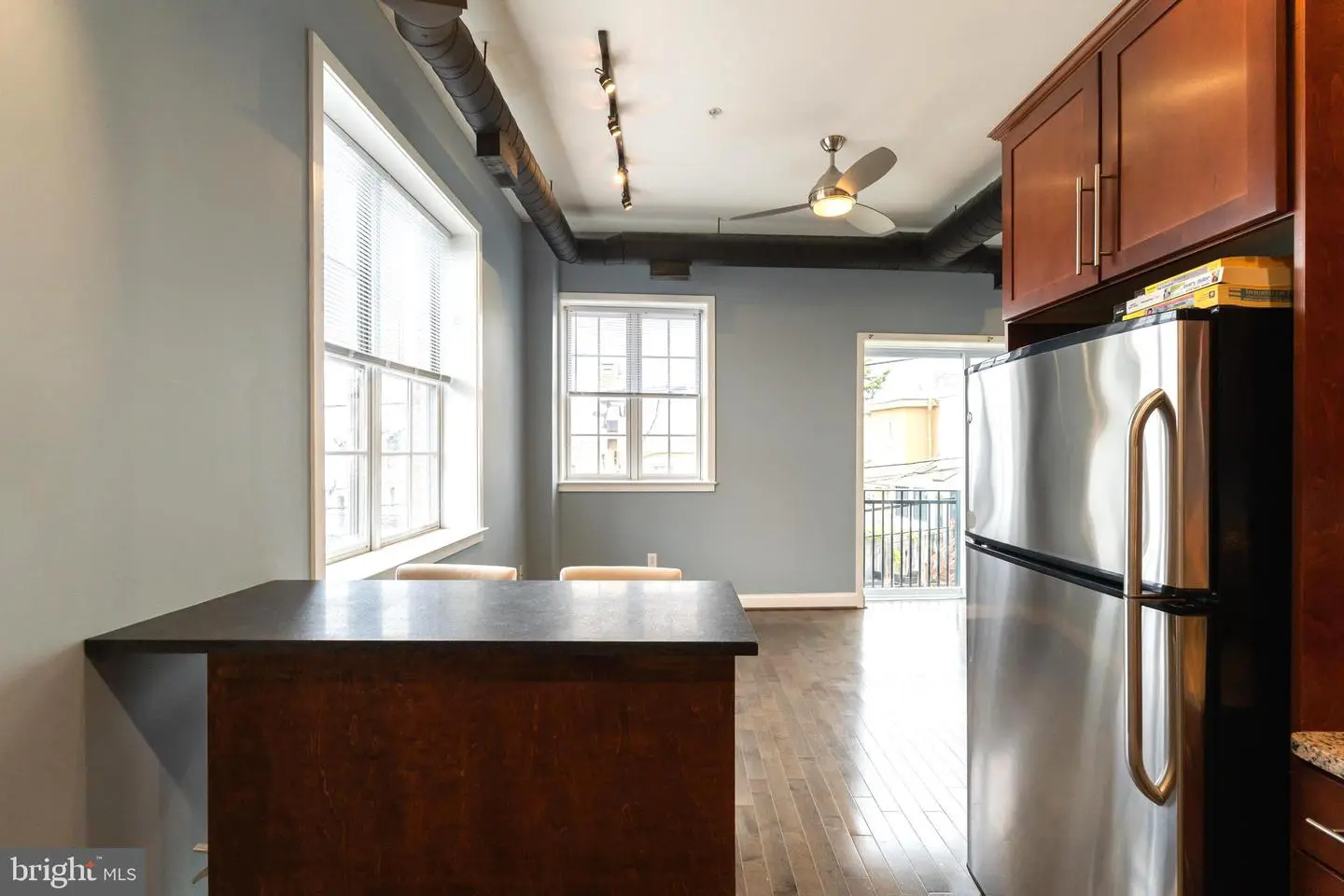 Open-concept kitchen with island and stainless refrigerator