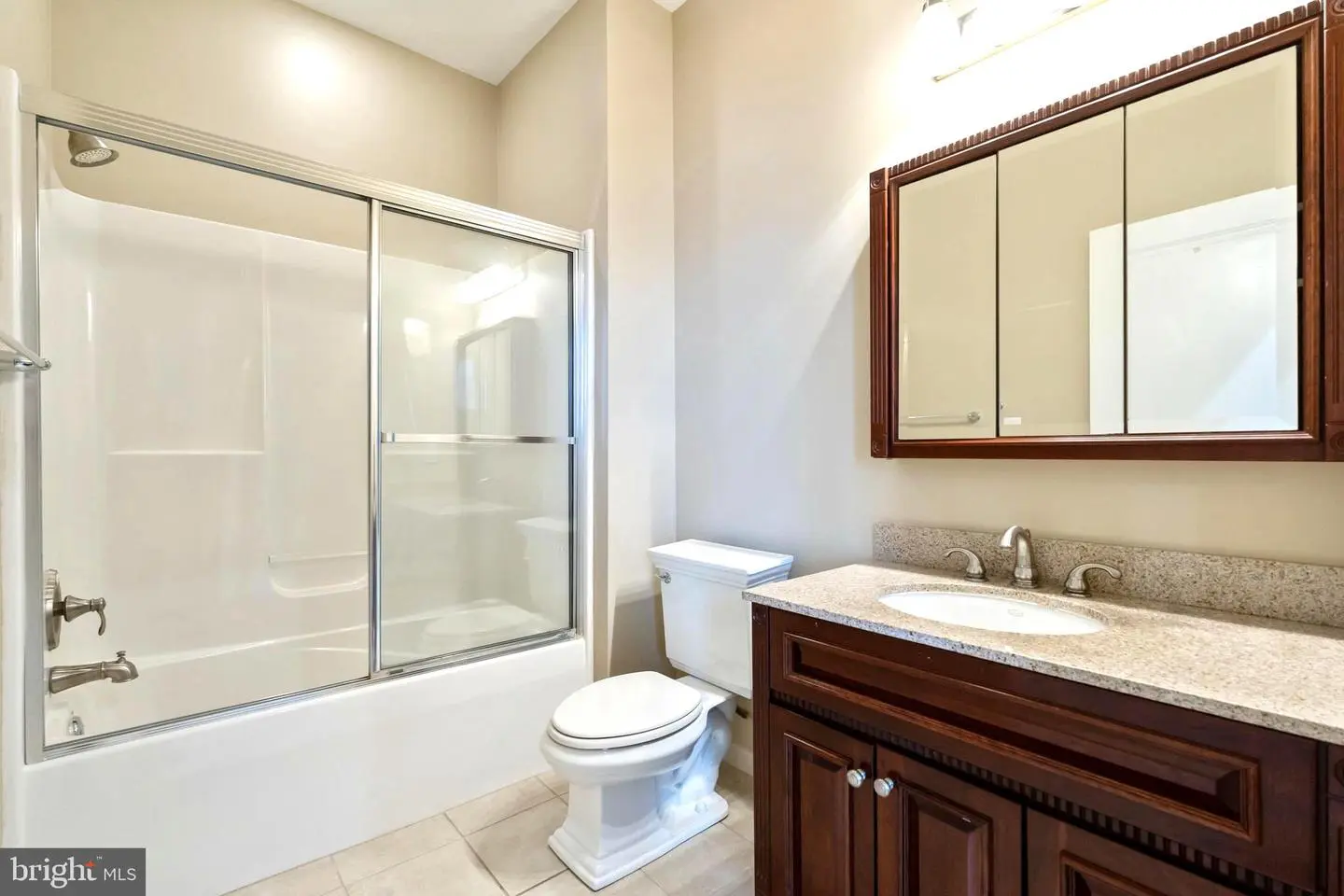 Bright bathroom with glass tub-shower and vanity