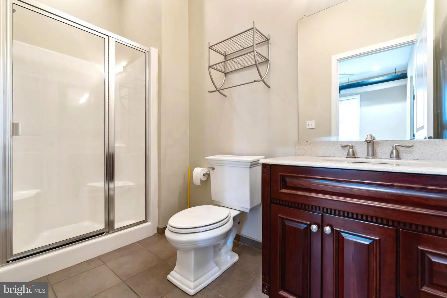 Bathroom with glass shower, toilet, wooden vanity