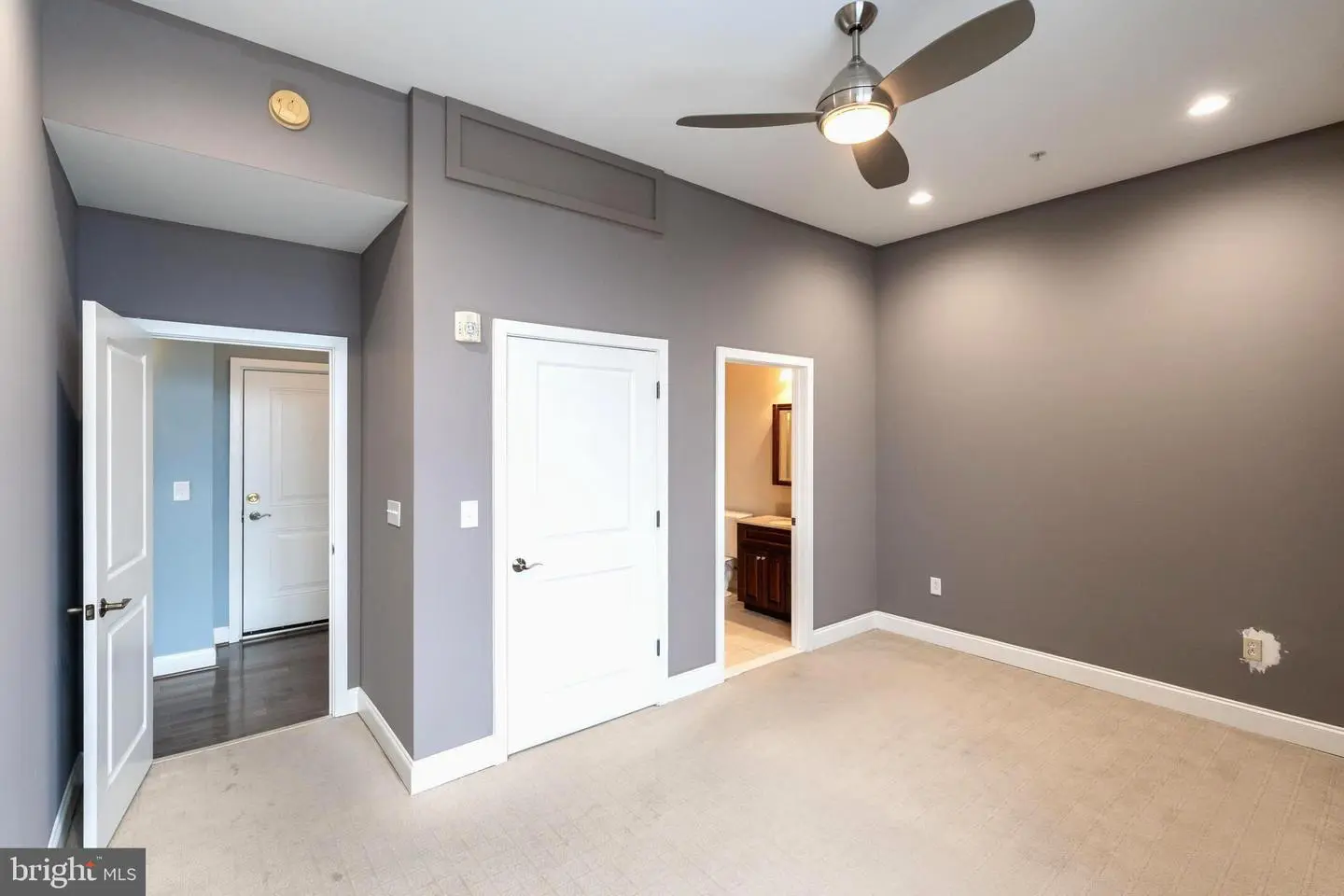 Empty bedroom with gray walls and ceiling fan