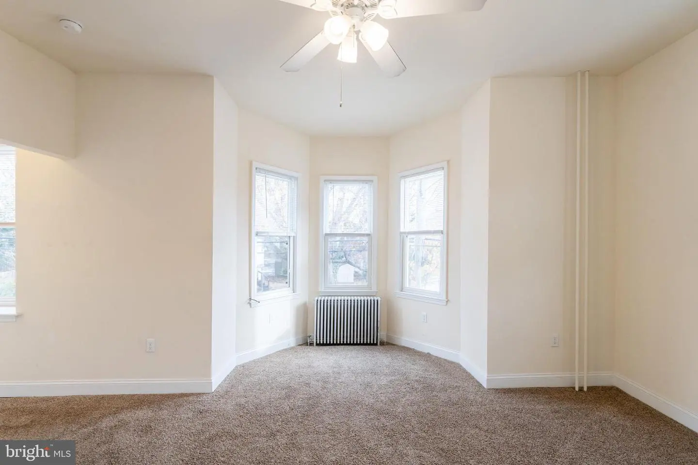 Empty carpeted room with bay windows