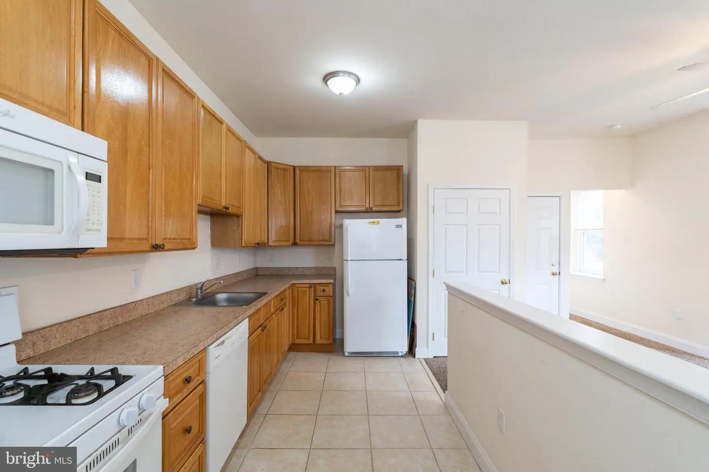 Bright kitchen with wooden cabinets and appliances