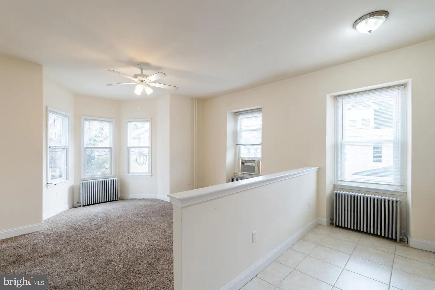 Empty apartment living room with bay windows