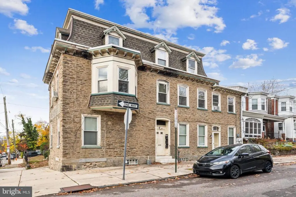 Historic brick corner rowhouse with parked car