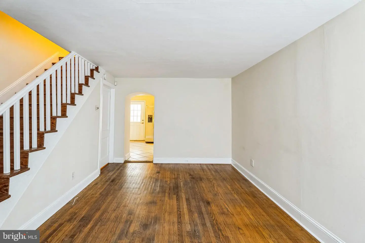 Empty living room with hardwood floors and staircase