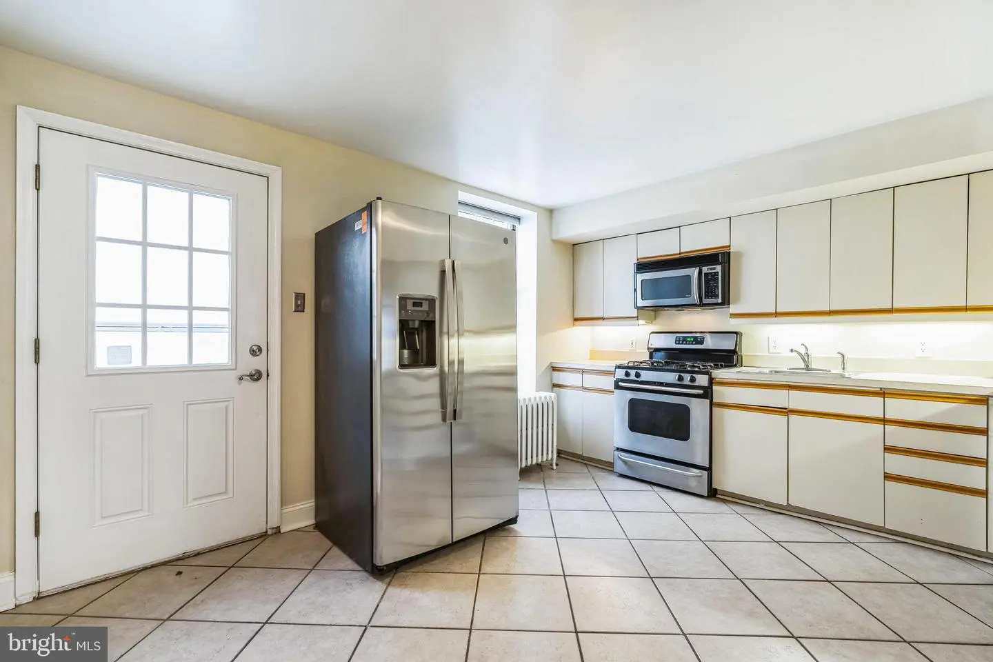 Spacious tiled kitchen with stainless appliances