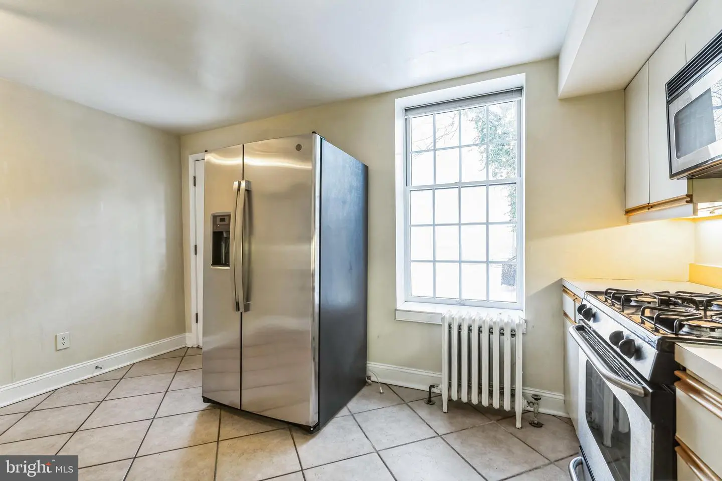 Empty kitchen with stainless steel refrigerator