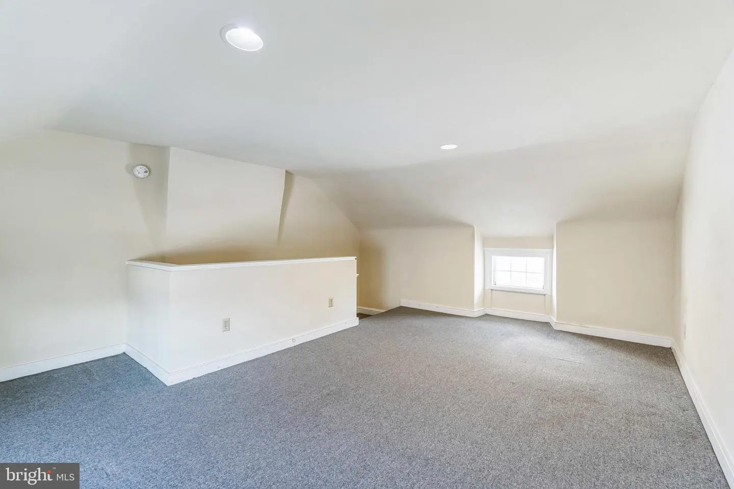 Empty finished attic room with dormer window
