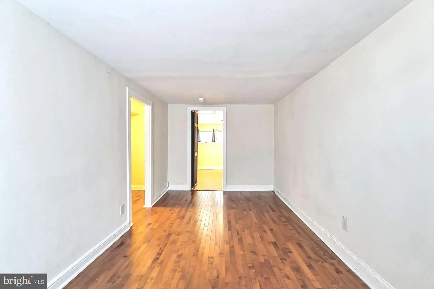 Empty narrow living room with hardwood floors