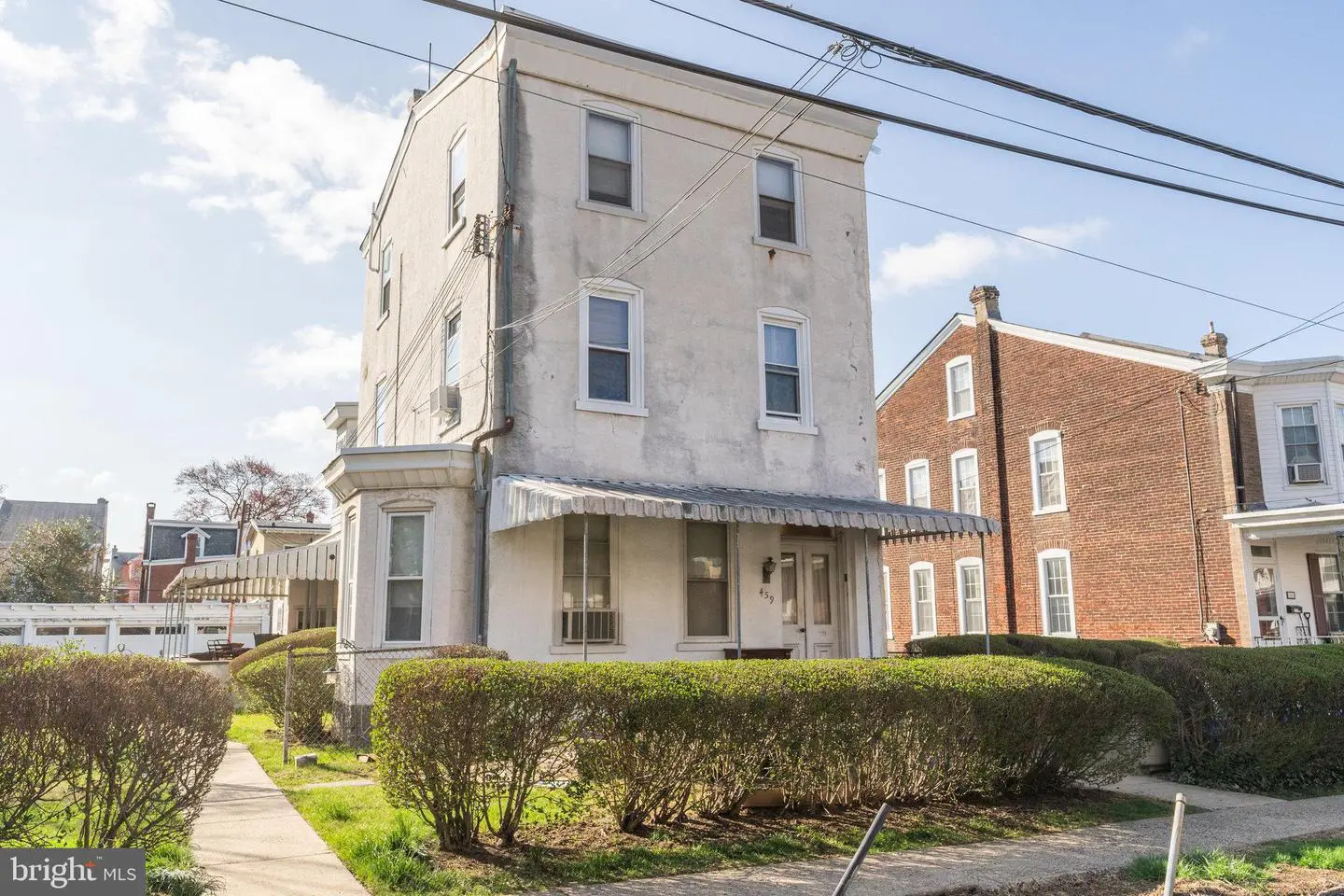 Three-story corner rowhouse with front awning