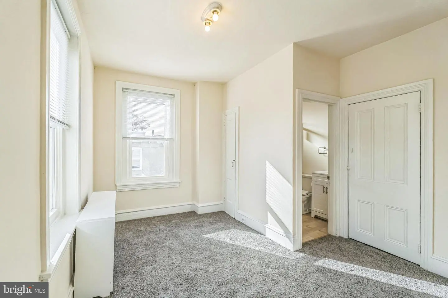 Bright empty bedroom with gray carpet