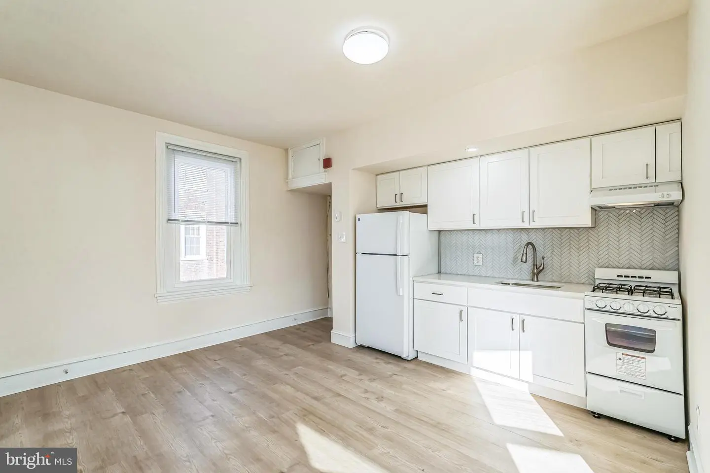 Bright studio kitchen with white cabinets