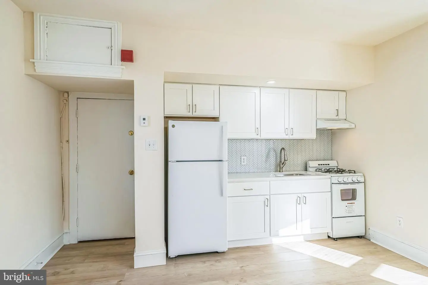 Small studio kitchen with white cabinets
