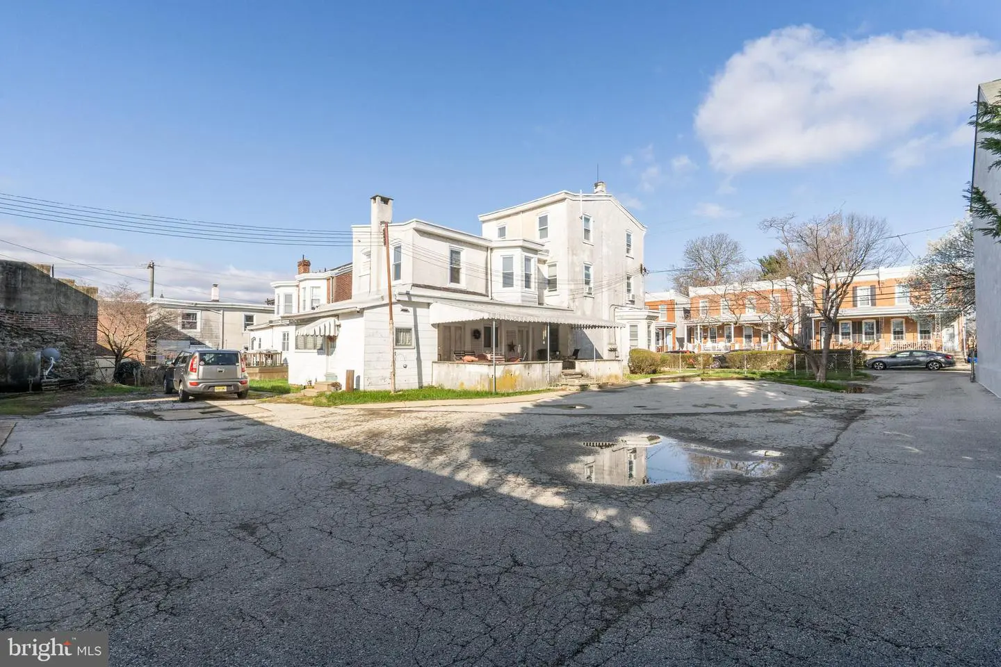 White multi-story building by cracked parking lot