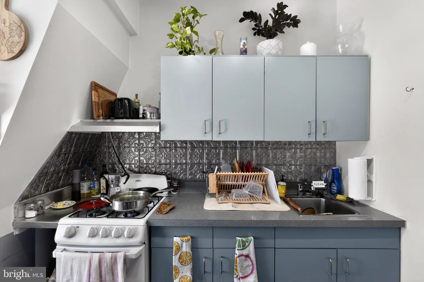 Compact kitchenette with blue cabinets and stove
