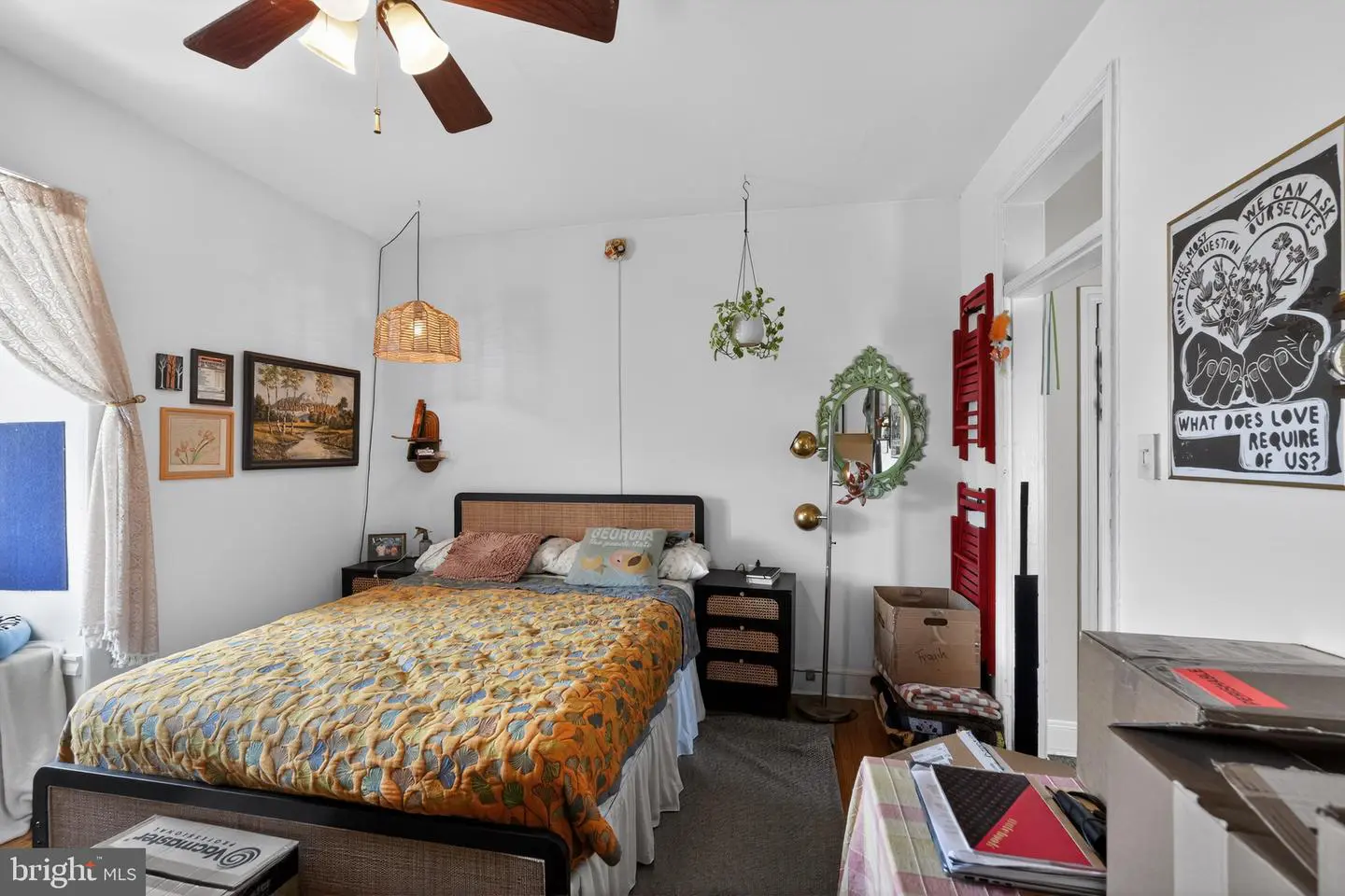Bright eclectic bedroom with orange quilted bedspread