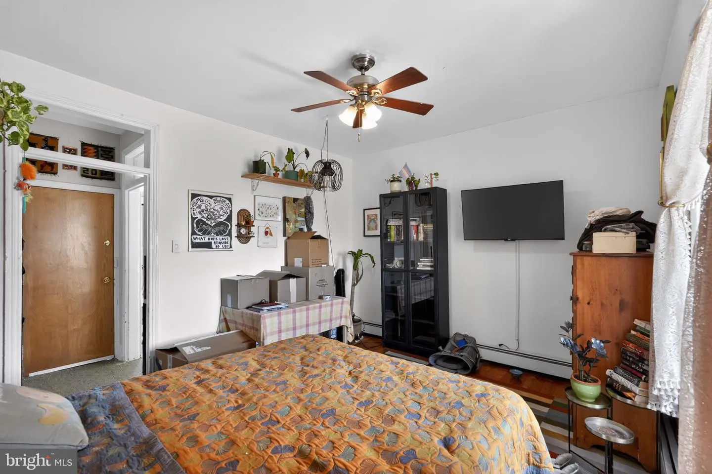 Cozy bedroom with patterned quilt and TV