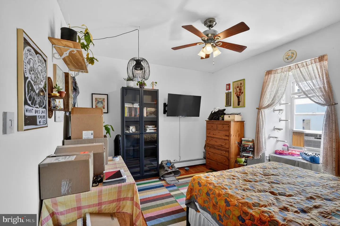 Cozy bedroom with colorful quilt and bookshelf