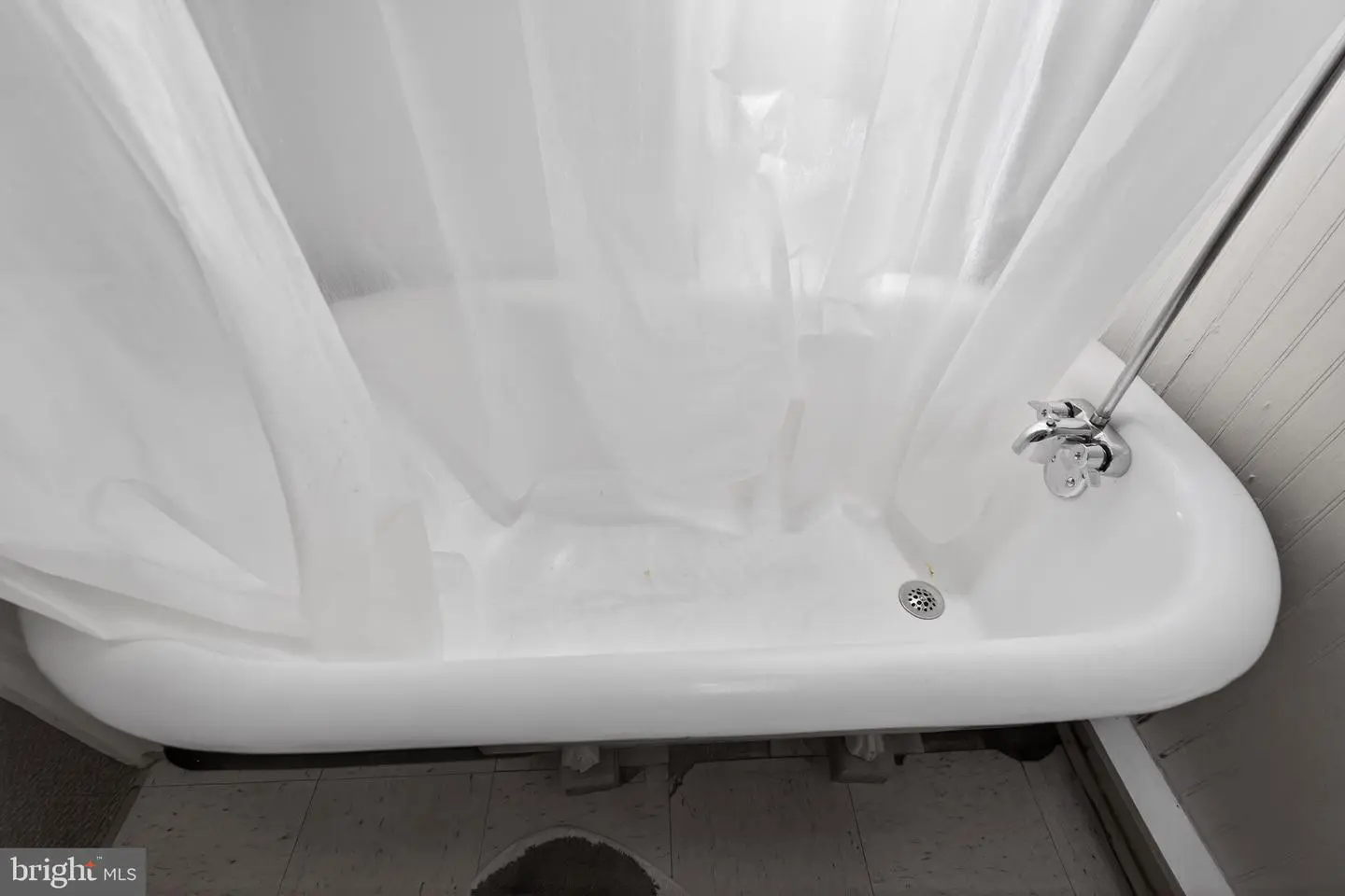 White bathtub with translucent shower curtain