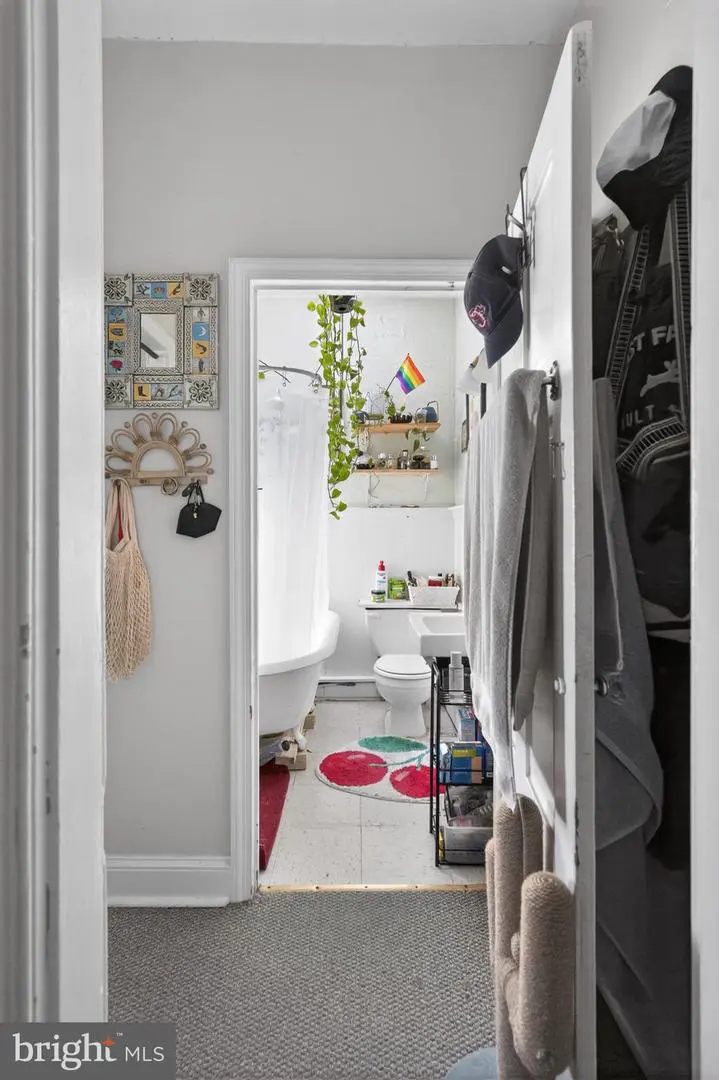 Apartment bathroom with clawfoot tub and pride flag