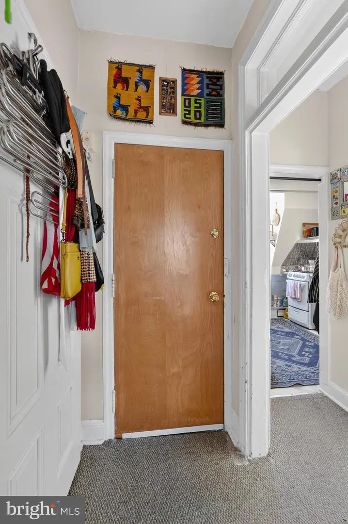 Hallway with wooden door and colorful wall textiles
